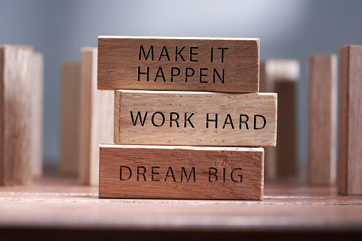 Positive inspirational motivational words on wooden blocks - Dream big. Work hard, Make it happen.