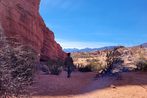 Woman Hiking to the Double Arch Sandstone Rock Formation. The Windows Section Trail with Doble Arch, Natural Wonder in Arches National Park, Utah, United States.