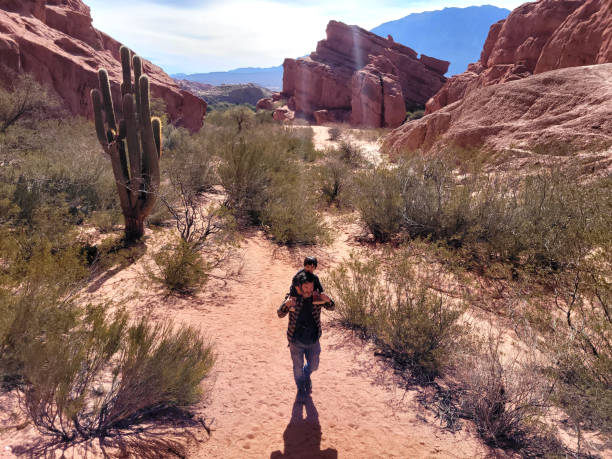 istock man with child walking through rocky valley 1422565218