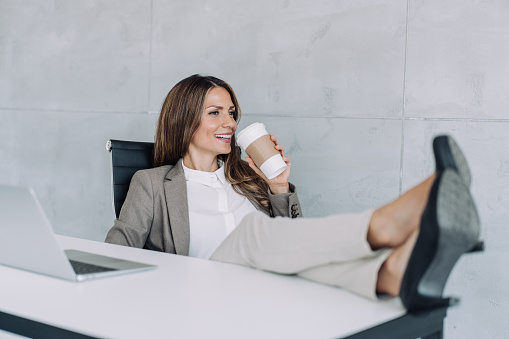 Young businesswoman relaxing with her feet on the desk.