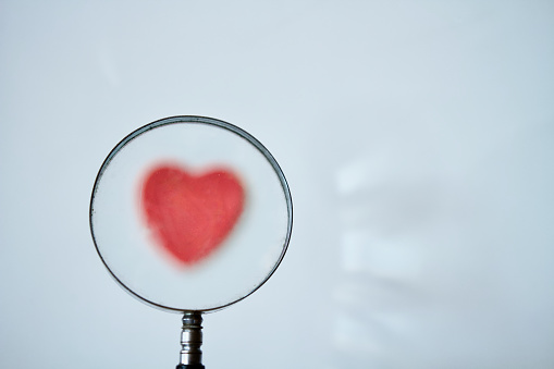 Metaphor of magnifying glass looking at heart shape
