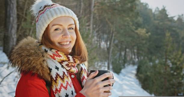 istock Ginger-haired woman walks in pine forest drinking coffee 1422587843