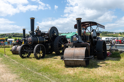 West Bay.Dorset.United Kingdom.June 12th 2022.A row of restored traction engines and steam rollers are on display at the West Bay vintage rally