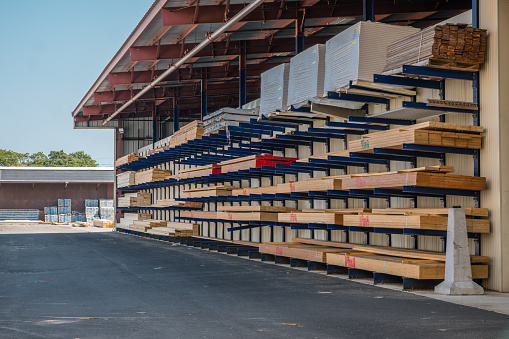 Stacks of lumber being stored in a at a lumber yard.