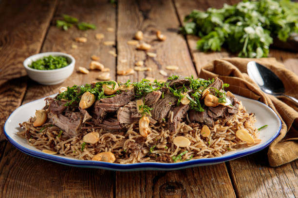 ouzi lamb or lamb pulao with nuts served in a dish side view isolared on wooden table stock photo