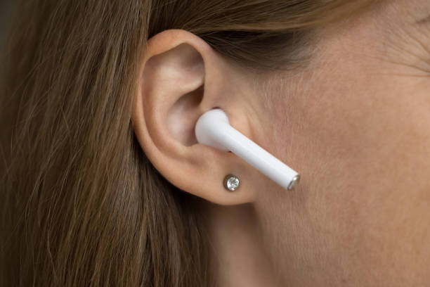 istock Wireless earphone object in female ear close up 1422599559