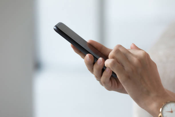istock Black mobile phone in female hands close up side view 1422599658