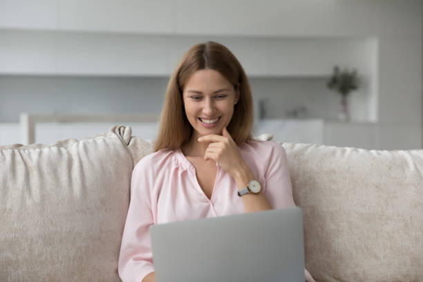 istock Happy pretty young woman using laptop at home 1422599837