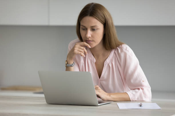 istock Focused thoughtful freelance employee woman working in home kitchen 1422599844