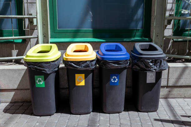 istock Colorful trash cans for sorting garbage. For plastic, glass, paper and others waste. Waste containers for garbage segregation in Poland, standing next to a wall 1422600478