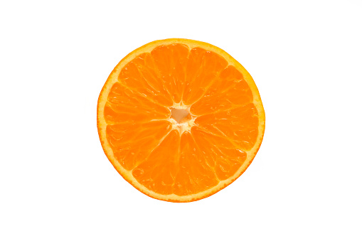 Stock photo showing elevated view of citrus fruit slice on white background, modern minimalist photo of sliced satsuma showing segments, seeds / pips and rind around edge, healthy eating concept photo for vitamin C and fruit juice.