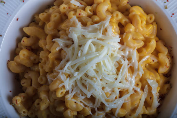 istock Mac and cheese, american style macaroni pasta with cheesy sauce on dark rustic table, top view 1422611200