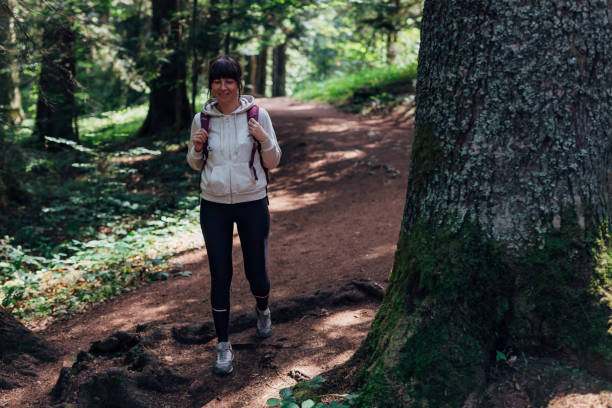 istock Young woman hiking through the forest 1422614122
