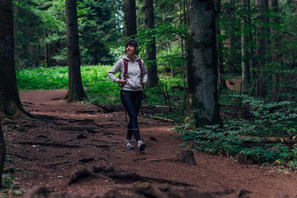 istock Young woman hiking through the forest 1422614189