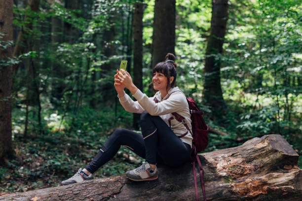 istock Young adventurous woman is making selfie in the forest 1422614235