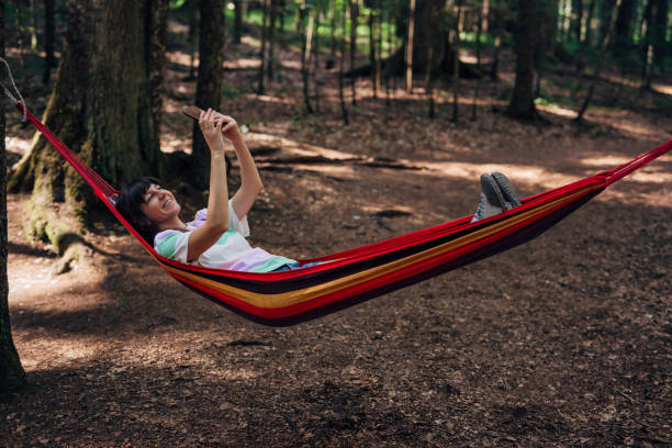 istock Young woman is making selfie in her hammock in the forest 1422614714