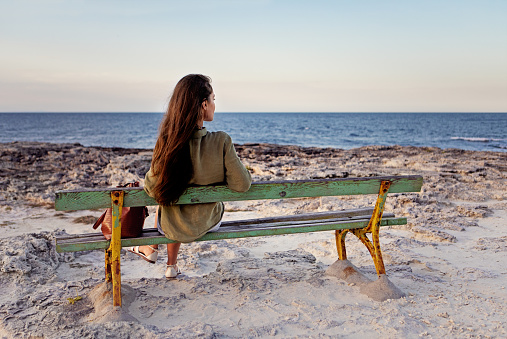 Young woman is looking sunset over an ocean