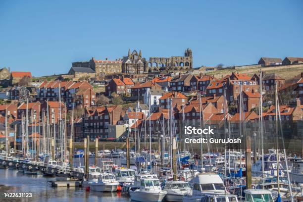 Boats On A River With Houses On A Hill Topped By A Ruined Abbey On A Bright Sunny Day Stock Photo - Download Image Now
