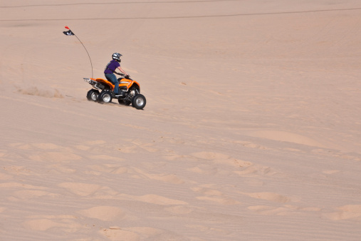 A single ATV crossing the Sand Dunes in California's Imperial Sand Dunes near Yuma Arizona at Glamis Dunes