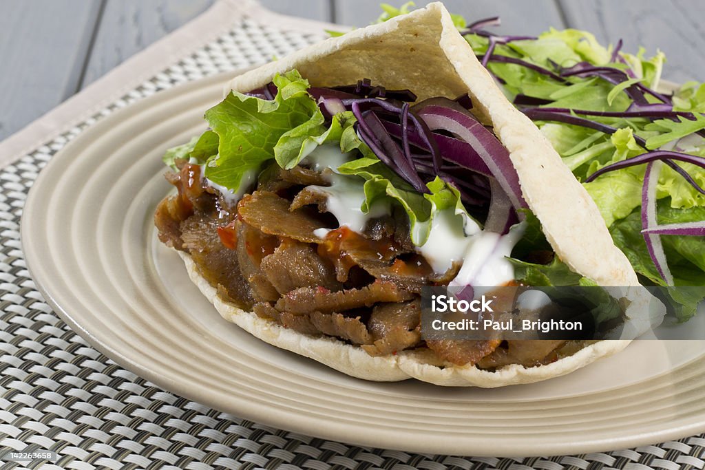 Give Kebab / Gyro Donner Kebab - Turkish donner meat in a pitta bread served with chili sauce, garlic mayonnaise and crunchy salad Beef Stock Photo