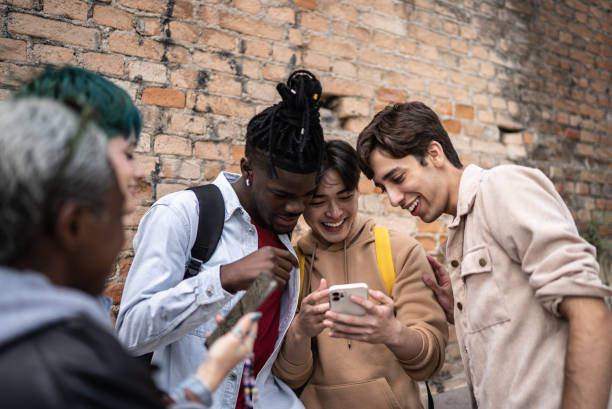 istock Friends using the mobile phone in the street 1422641429
