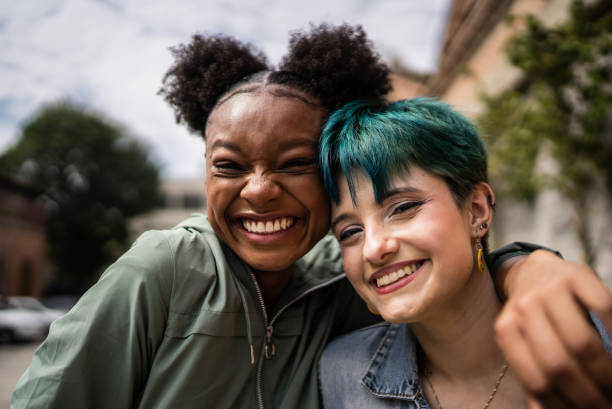 porträt von freunden, die sich auf der straße umarmen - human gender people women young women stock-fotos und bilder