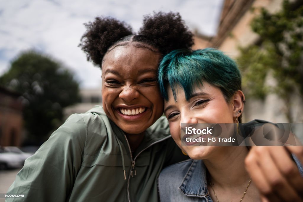 Portrait of friends embracing in the street Teenager Stock Photo
