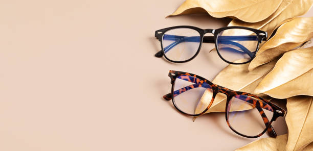 istock Stylish eyeglasses over pastel background. Optical store, glasses selection, eye test, vision examination at optician, fashion accessories concept. Top view, flat lay 1422643378
