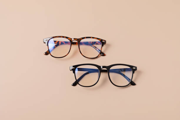 istock Stylish eyeglasses over pastel background. Optical store, glasses selection, eye test, vision examination at optician, fashion accessories concept. Top view, flat lay 1422643379