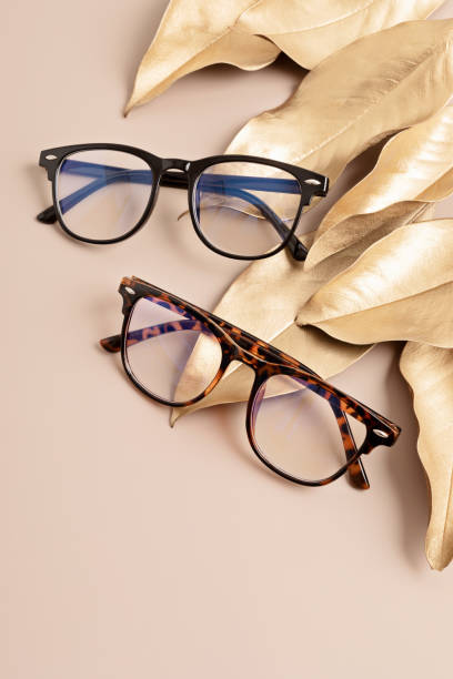 istock Stylish eyeglasses over pastel background. Optical store, glasses selection, eye test, vision examination at optician, fashion accessories concept. Top view, flat lay 1422643385