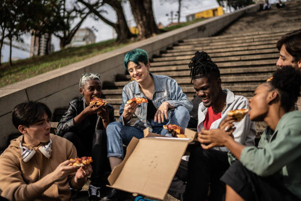 istock Friends eating pizza in the park 1422644310