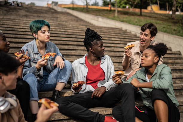 istock Friends eating pizza in the park 1422644316