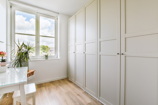 A small dressing room with large monolithic white wardrobes in a modern house