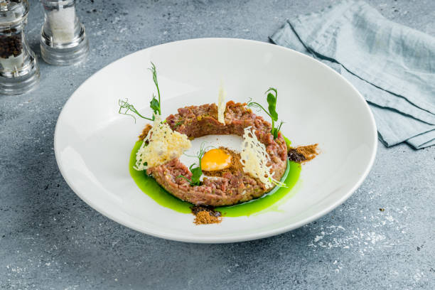 istock Tartare from beef with egg on white plate on grey table 1422650696