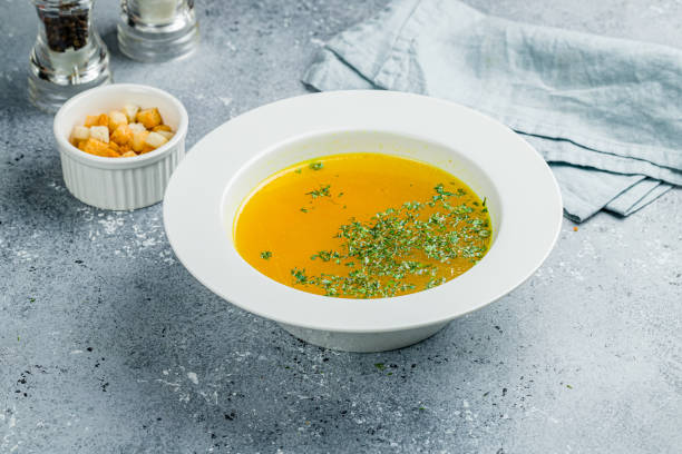 istock Chicken soup bouillon in a plate on grey table 1422651403