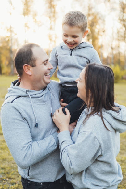 istock Happy caucasian family hugging while posing together. Active kid playing outdoors. Family happiness love concept. 1422654712