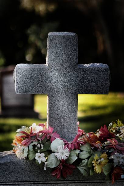 istock Flowers On A Cross Headstone At Gravesite 1422680224