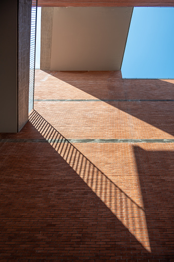 Red brick wall and sunlight projection under blue sky and white clouds