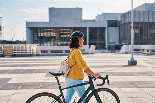 Carbon footprint, sustainable and travel woman with bike to university or college for fitness, health and wellness. Motivation, exercise and happy young gen z student with bicycle gear in urban city