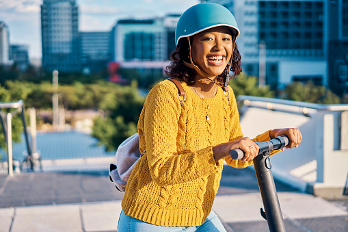 Happy, electric and girl on scooter travel in urban city relax, having fun and adventure in town. Happiness, smile and fast transportation for young black woman with helmet for safety and security
