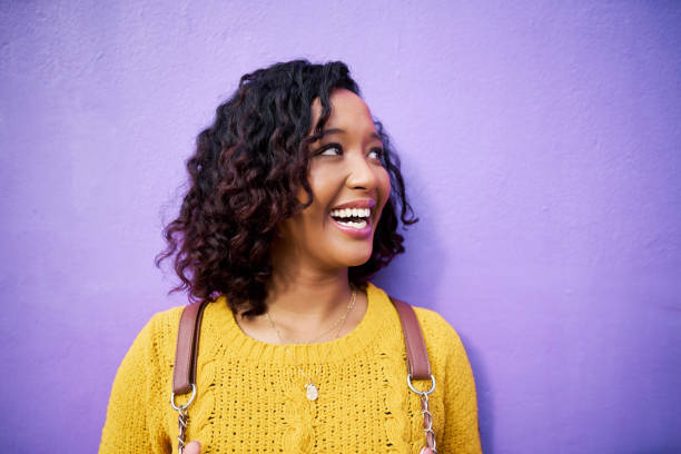 istock Education, learning and a black woman student with a smile and backpack on purple background. University, college or scholarship for young happy girl. Celebration of a bright future, beauty and youth 1422684674