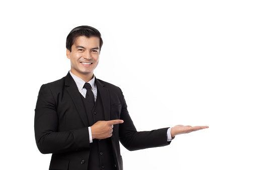 Businessman smiling, holding open palm with empty copy space. Business man showing hand sign to side concept of advertisement product isolated on white background.