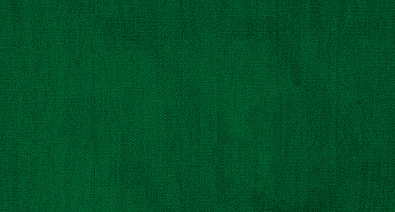 green carpet background texture, shot from above. texture tight weave carpet. elegant dark green color background of the carpet.