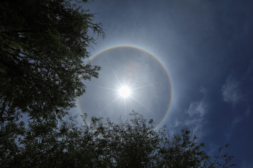 A  Sun halo is an optical phenomenon in the form of a halo around the sun. The sun seems to be surrounded by a ring of light similar to the glow of a lamp. This phenomenon does not only occur in sunlight, but also occurs in moonlight, lighting and the light of the earth's surface.