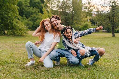 Photo of a smiling teenage girls having fun outdoors in the park after school