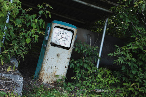 alte rostige verlassene tankstelle mit gras und bäumen bewachsen - old station natural gas russia stock-fotos und bilder