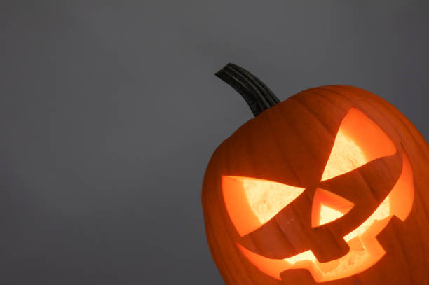 zucca di halloween su grigio - carved letters foto e immagini stock