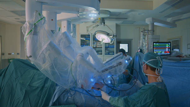 surgeon doing laparoscopic surgery in hospital with a medical robot - robotchirurgie stockfoto's en -beelden