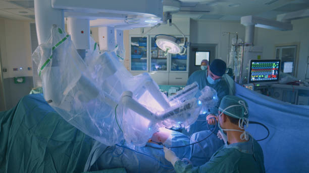 Surgeon doing laparoscopic surgery in hospital with a medical robot stock photo