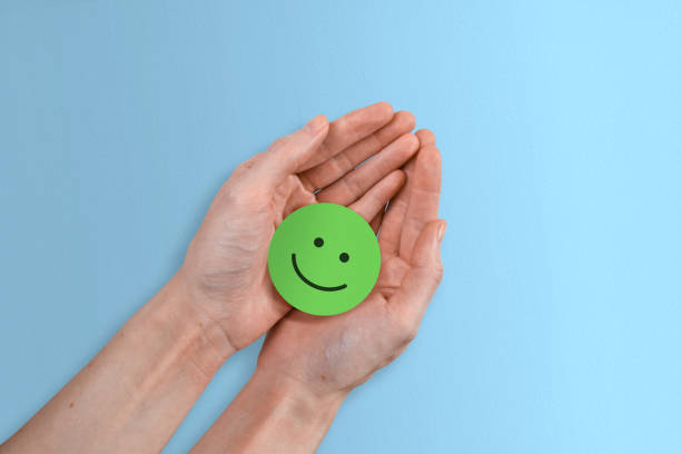 istock Positive Green Smiley Concept - Successful Paper Smiley Face on Blue Background 1422722580